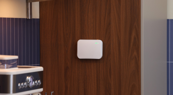 Wireless Aeropulse indoor air quality sensor mounted on a wall with customer review for commercial indoor air monitoring.
