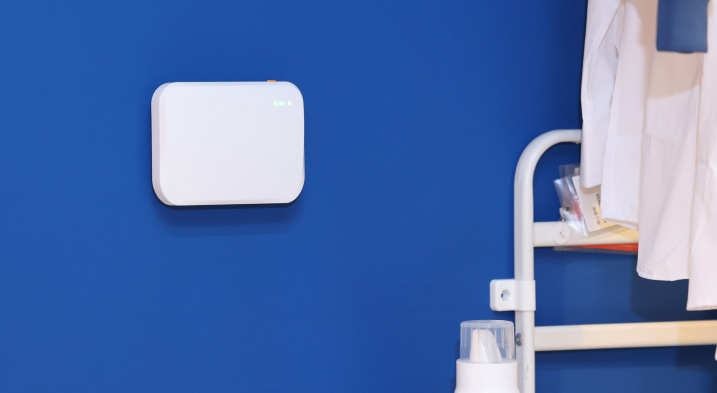 Aeropulse A100 indoor air quality monitor installed in a modern office with customer review highlighting easy installation and reliable IAQ monitoring.